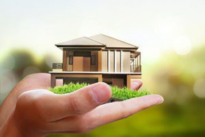 A person holding a small house in his hand