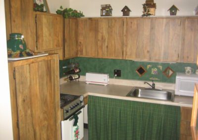 An inside image of a the kitchen with brown cabinets of garden style apartment at 211 LIBERTY STREET CARMICHAELS, PA 15320